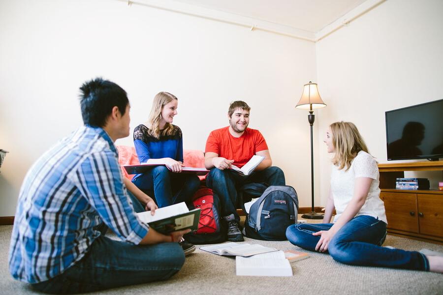 四个学生在一间公寓的客厅里学习.