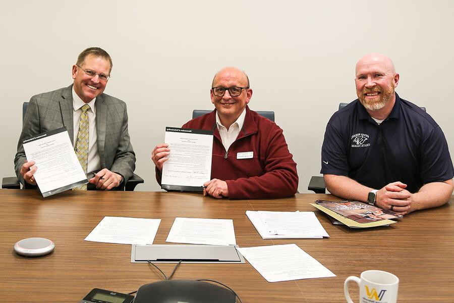 Two NWU employees and two WNCC employees signing agreement 
